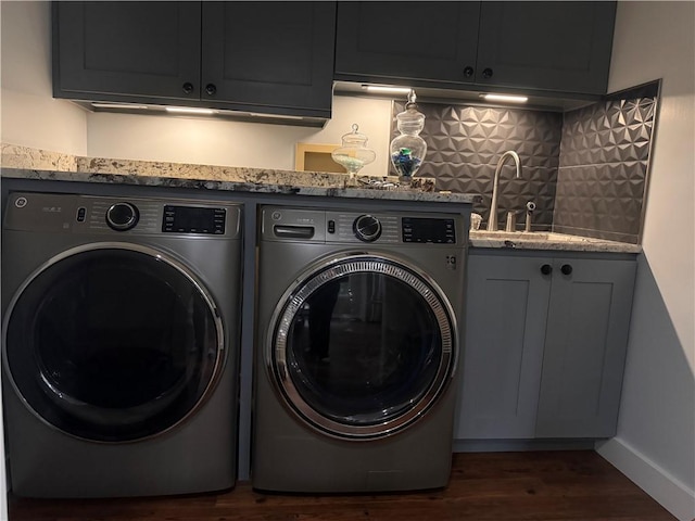 washroom with cabinets, dark hardwood / wood-style flooring, wet bar, and washing machine and clothes dryer