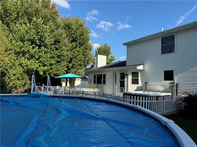 view of swimming pool with a hot tub