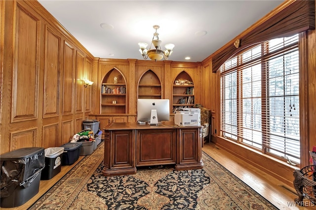 office with hardwood / wood-style flooring, built in features, and a chandelier