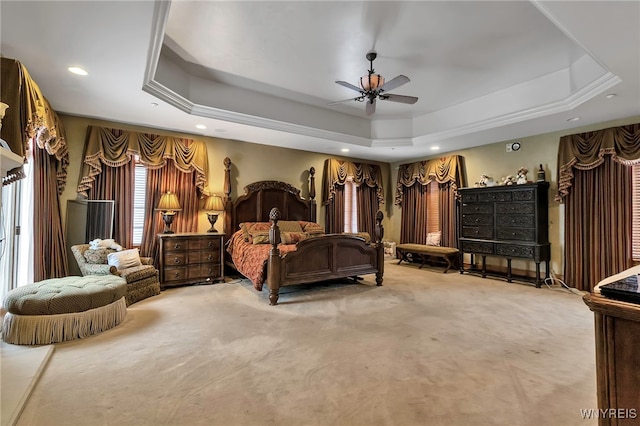 carpeted bedroom with a tray ceiling and ceiling fan