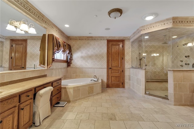 bathroom with vanity, separate shower and tub, and tile walls