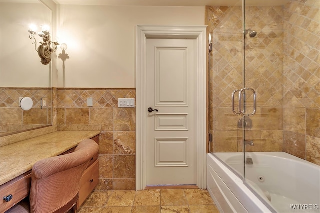 bathroom with vanity, tile walls, and shower / bath combination with glass door