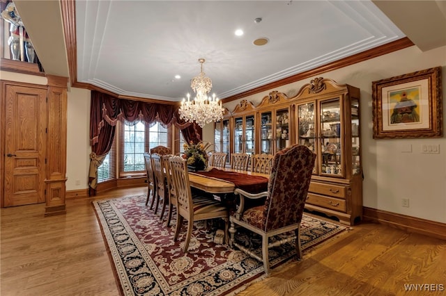 dining space featuring crown molding, light hardwood / wood-style floors, and a notable chandelier