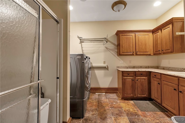 laundry room featuring washing machine and dryer and cabinets