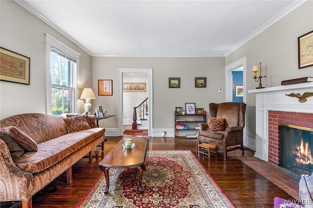 living room featuring dark hardwood / wood-style flooring, a brick fireplace, and crown molding