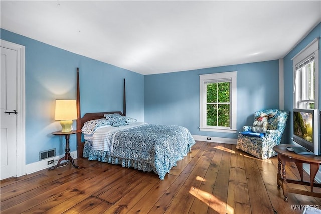 bedroom featuring hardwood / wood-style flooring and multiple windows