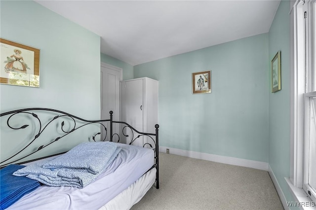 bedroom featuring multiple windows and light carpet