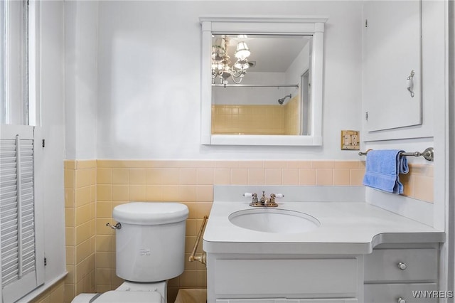 bathroom with vanity, tile walls, and toilet