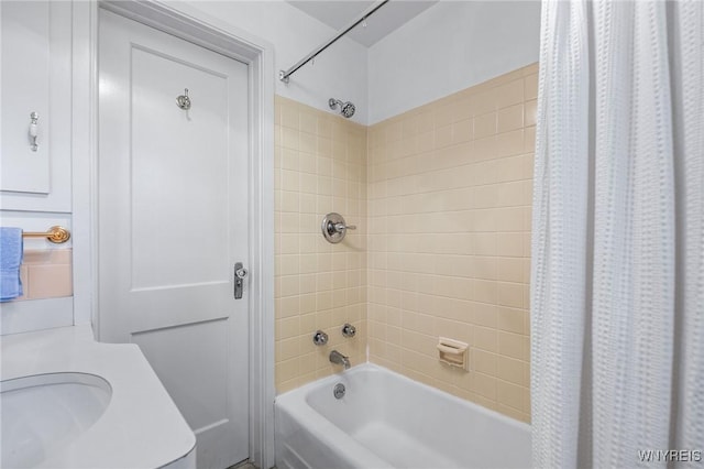 bathroom with shower / bathtub combination with curtain and sink