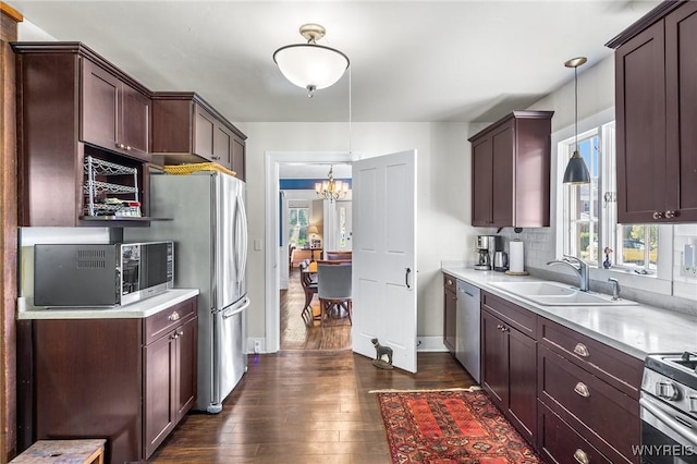 kitchen with pendant lighting, sink, dark hardwood / wood-style floors, and appliances with stainless steel finishes