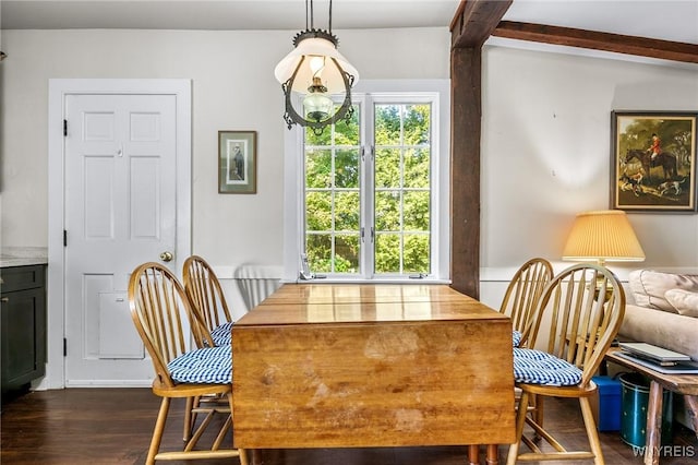 dining area with dark hardwood / wood-style flooring and beamed ceiling