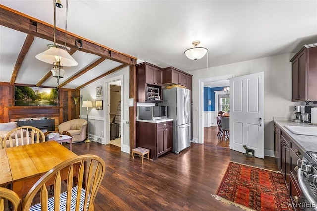 kitchen with appliances with stainless steel finishes, a fireplace, vaulted ceiling with beams, dark hardwood / wood-style flooring, and hanging light fixtures