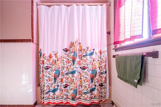 bathroom featuring tile walls and walk in shower