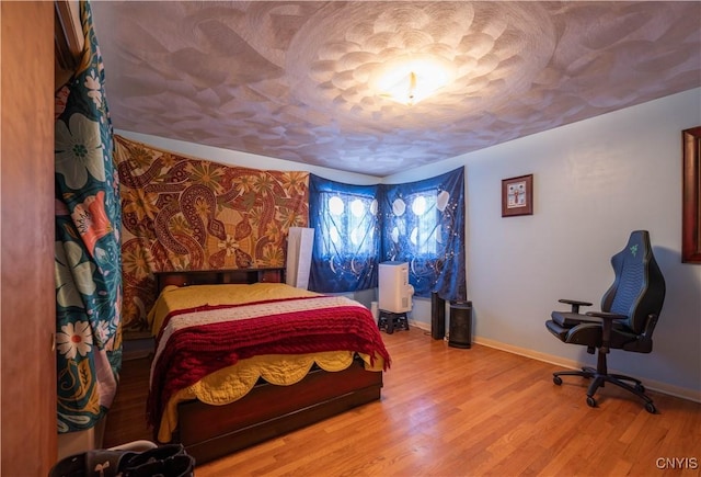 bedroom with wood-type flooring and a textured ceiling