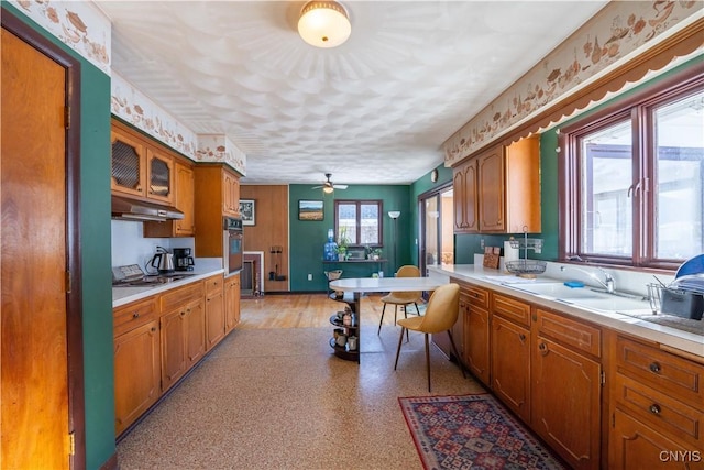 kitchen with gas cooktop, stainless steel oven, ceiling fan, and sink