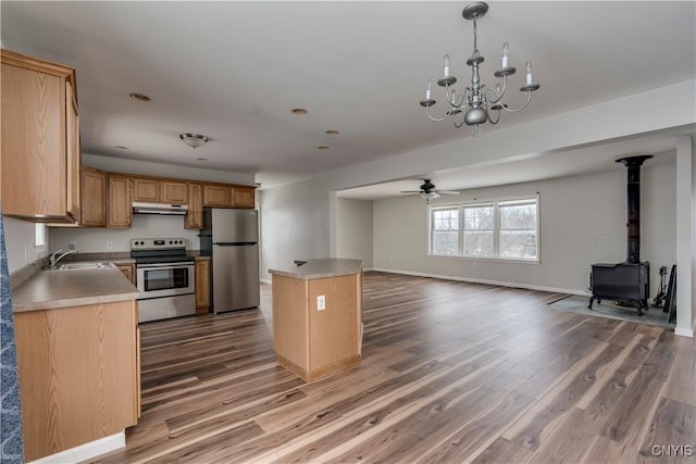 17200 Evans Rd, Hounsfield, NY 13634 - kitchen with a sink, ceiling fan with notable chandelier, a wood stove, open floor plan, and appliances with stainless steel finishes
