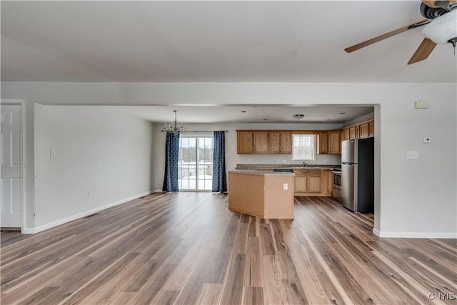 17200 Evans Rd, Hounsfield, NY 13634 - kitchen with freestanding refrigerator, open floor plan, ceiling fan with notable chandelier, and light wood finished floors