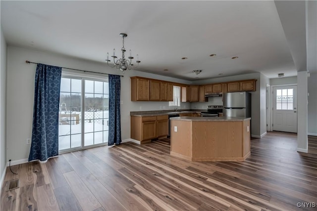 17200 Evans Rd, Hounsfield, NY 13634 - kitchen featuring baseboards, a notable chandelier, stainless steel appliances, and wood finished floors
