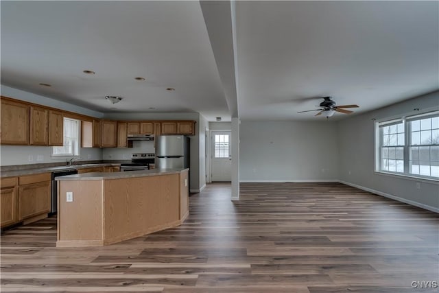 17200 Evans Rd, Hounsfield, NY 13634 - kitchen featuring under cabinet range hood, baseboards, open floor plan, wood finished floors, and stainless steel appliances