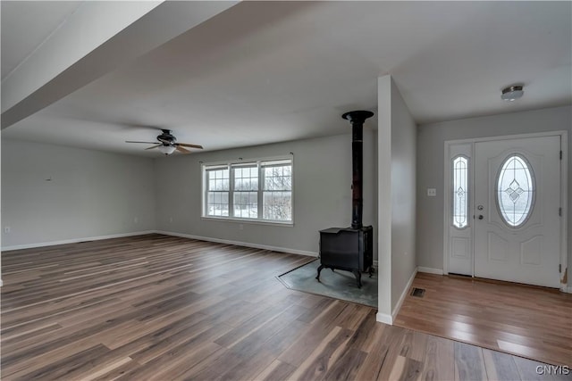 17200 Evans Rd, Hounsfield, NY 13634 - foyer entrance featuring a wood stove, wood finished floors, baseboards, and a ceiling fan