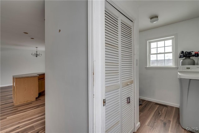 17200 Evans Rd, Hounsfield, NY 13634 - hallway featuring an inviting chandelier, visible vents, wood finished floors, and baseboards