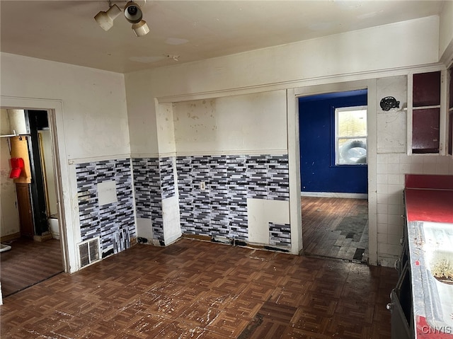 unfurnished room with tile walls and dark parquet floors