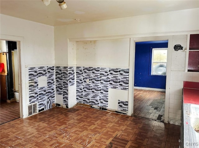 empty room with parquet flooring and tile walls