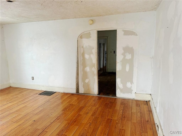 spare room with hardwood / wood-style flooring and a textured ceiling