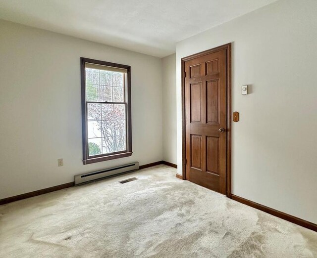 spare room with light colored carpet and a baseboard radiator