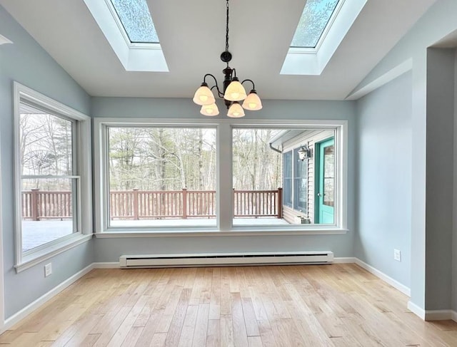 unfurnished dining area featuring vaulted ceiling, plenty of natural light, a baseboard heating unit, and light hardwood / wood-style flooring