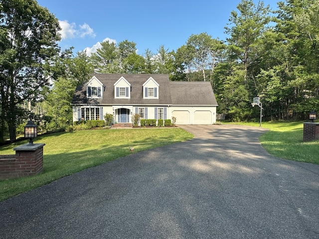 new england style home featuring a front yard and a garage