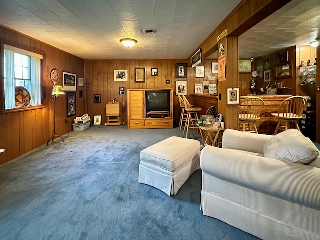 carpeted living room with wood walls and indoor bar