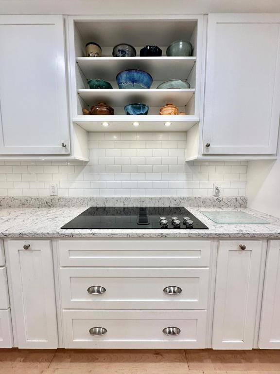 kitchen featuring white cabinetry and light stone countertops