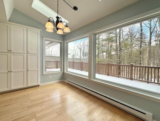 unfurnished dining area featuring vaulted ceiling, a chandelier, and baseboard heating