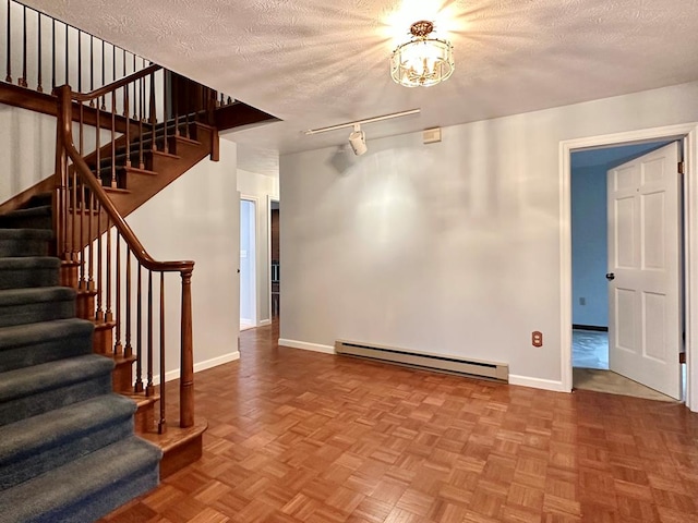 interior space featuring baseboard heating, a textured ceiling, and parquet flooring