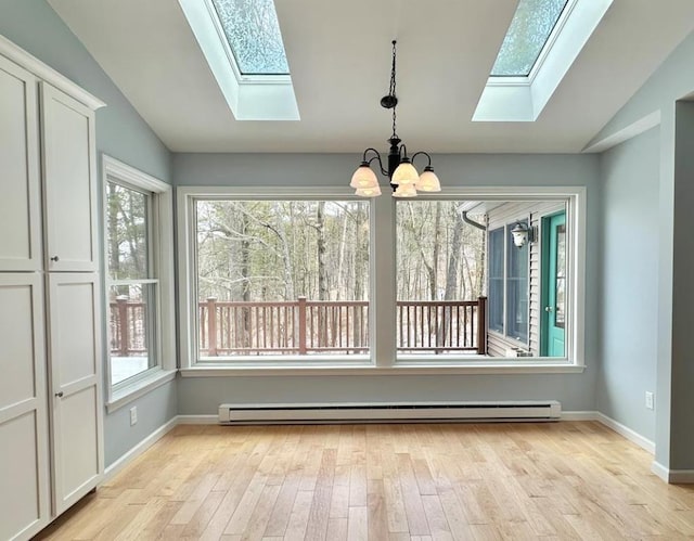 unfurnished dining area featuring a baseboard radiator, lofted ceiling with skylight, an inviting chandelier, and light hardwood / wood-style floors