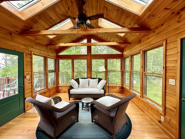 sunroom / solarium featuring ceiling fan, vaulted ceiling with skylight, and wooden ceiling