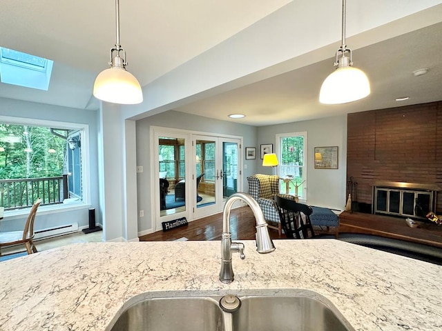 kitchen with sink, a skylight, hardwood / wood-style floors, and decorative light fixtures