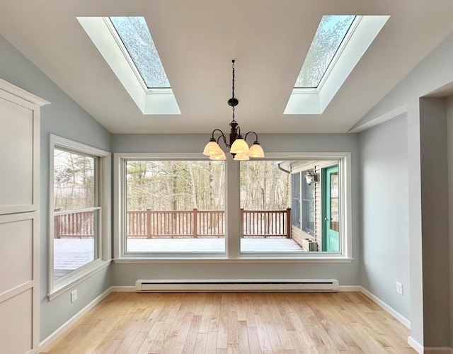 unfurnished dining area with light wood-type flooring, vaulted ceiling, and a baseboard radiator