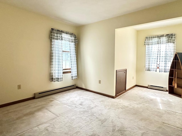 carpeted empty room featuring baseboard heating