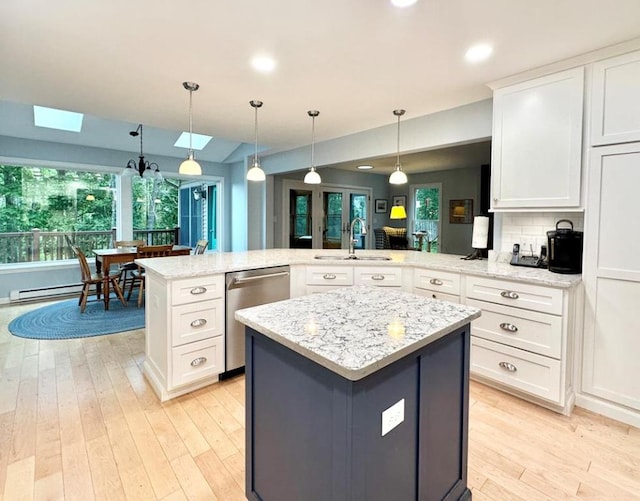 kitchen with white cabinetry, kitchen peninsula, decorative light fixtures, sink, and dishwasher