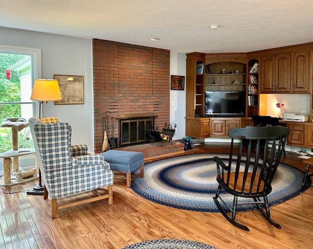 living room with light wood-type flooring and a fireplace