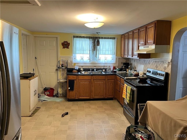 kitchen with tasteful backsplash, appliances with stainless steel finishes, and sink