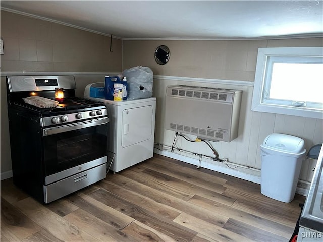 kitchen with washer / clothes dryer, stainless steel range with gas cooktop, hardwood / wood-style flooring, and heating unit