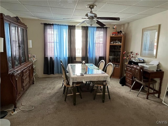 dining area featuring light carpet, a paneled ceiling, and ceiling fan