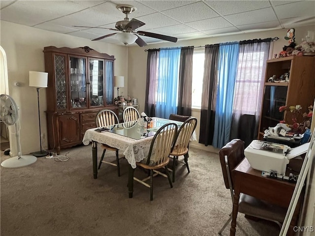 carpeted dining room featuring ceiling fan and a paneled ceiling