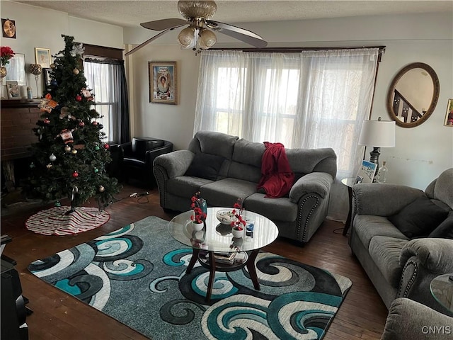 living room with a textured ceiling, plenty of natural light, dark hardwood / wood-style floors, and ceiling fan