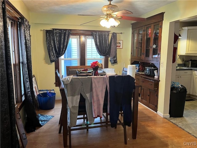 dining space with hardwood / wood-style floors and ceiling fan