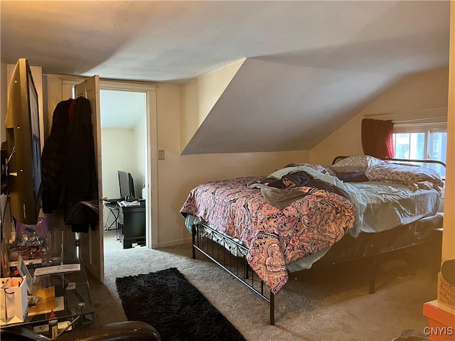 carpeted bedroom with lofted ceiling