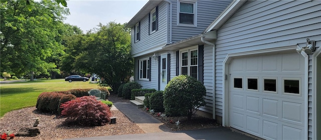 view of home's exterior featuring a garage and a yard